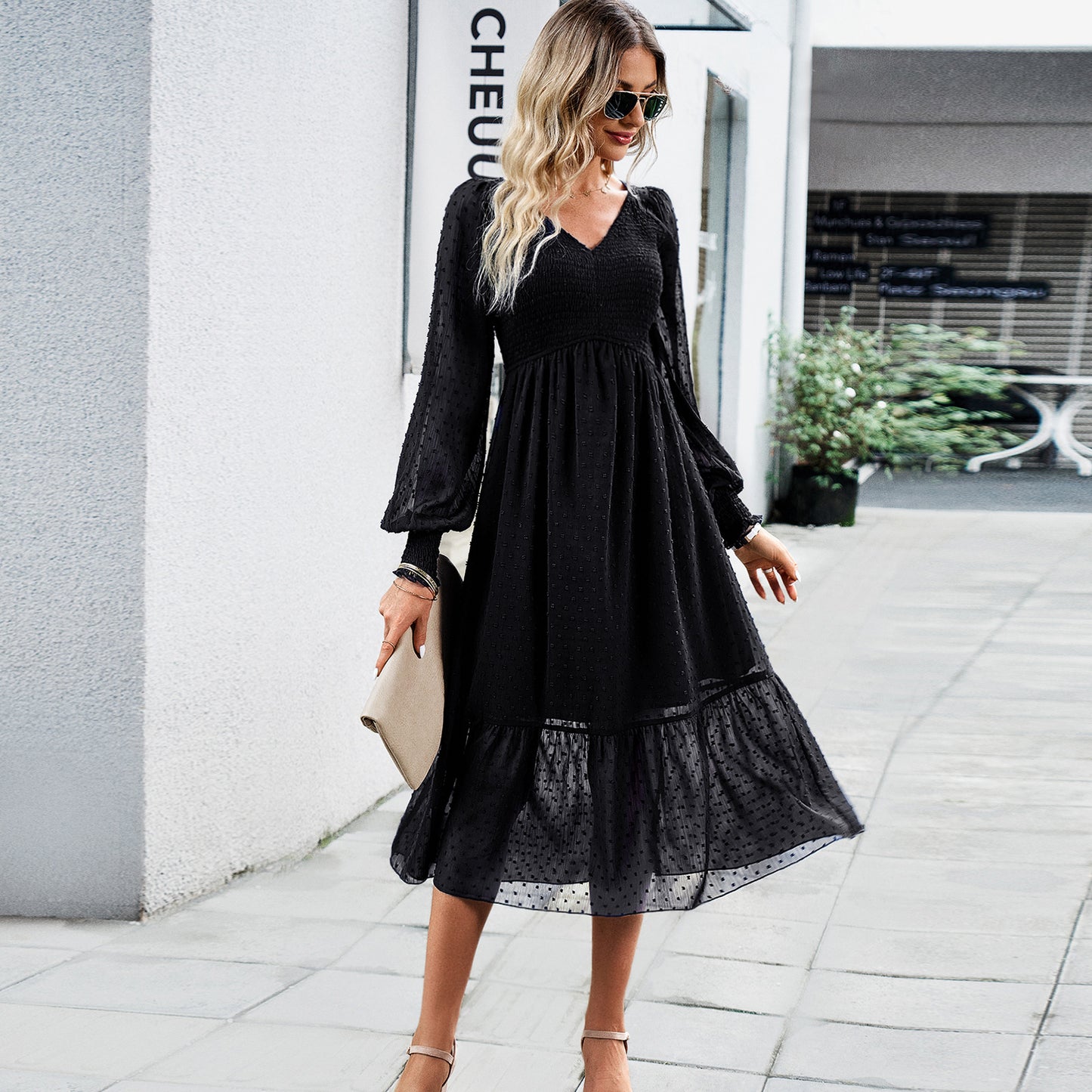 a woman wearing a black dress and heels