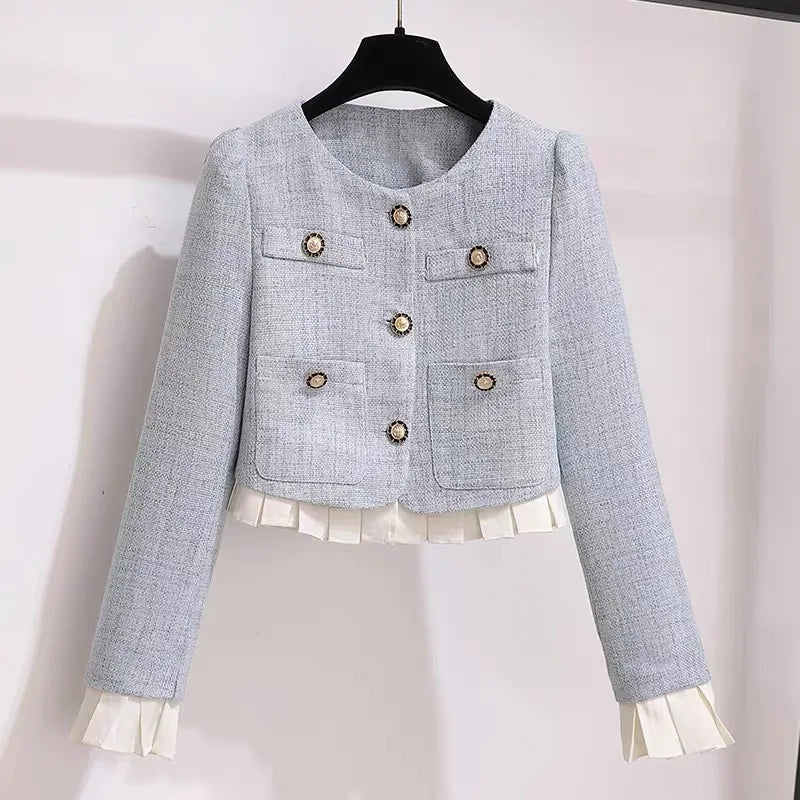 a blue jacket with white ruffles hanging on a wall